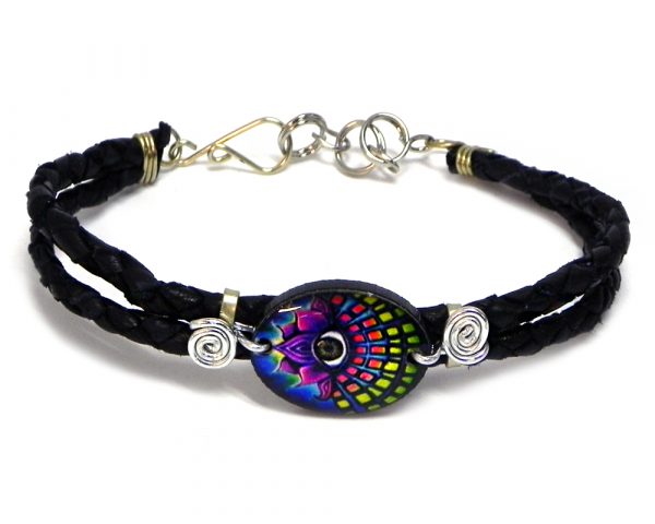 Handmade braided dyed leather bracelet with silver metal wire and oval-shaped acrylic New Age themed third eye lotus flower graphic design centerpiece in black, purple, and multicolored color combination.