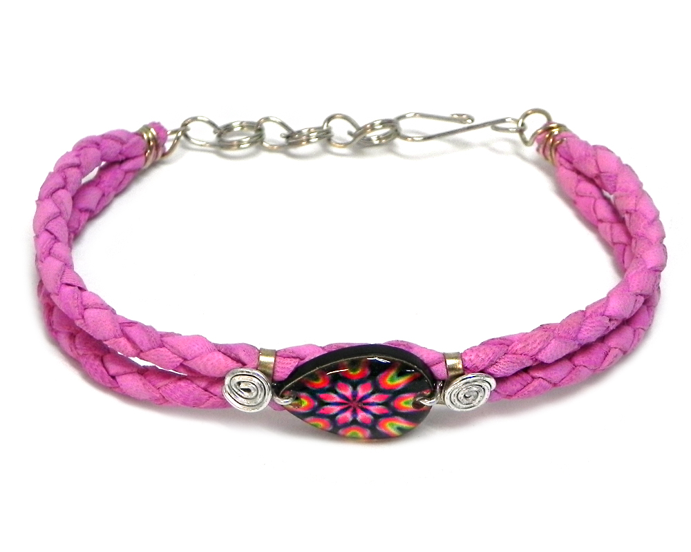 Handmade braided dyed leather bracelet with silver metal wire and teardrop-shaped acrylic New Age themed psychedelic mandala graphic design centerpiece in pink, hot pink, black, and lime green color combination.