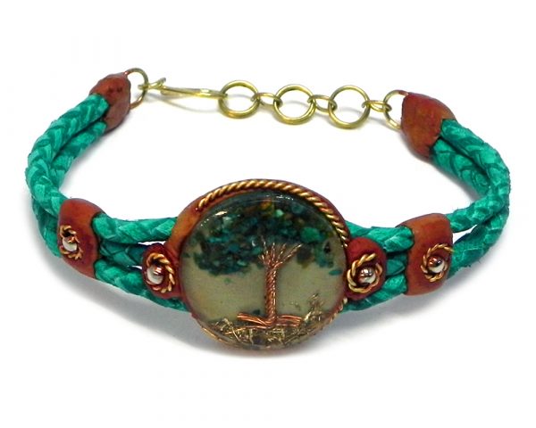Handmade braided dyed leather bracelet with brown resin, gold-colored metal, and round-shaped clear acrylic resin, copper wire, and crushed chip stone inlay tree of life centerpiece in teal green color.