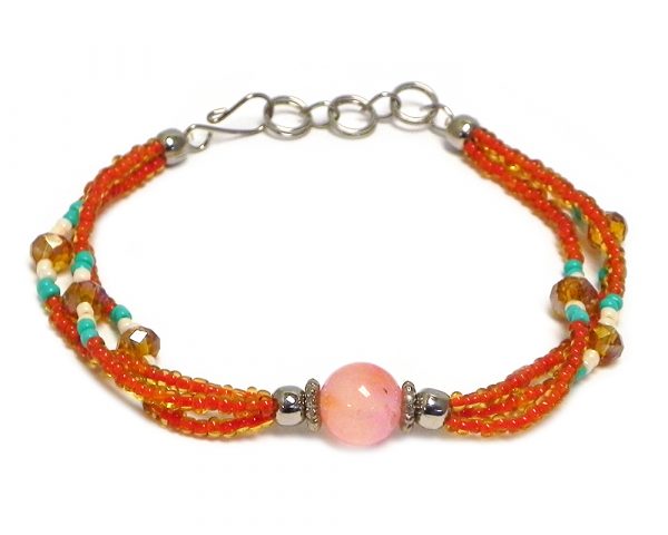 Handmade seed bead and crystal bead multi strand bracelet with tumbled orange agate gemstone crystal ball bead centerpiece in orange, mint green, and pearl white color combination.