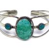 Handmade silver metal cuff bracelet with large oval-cut gemstone crystal cabochon centerpiece in teal green chrysocolla.