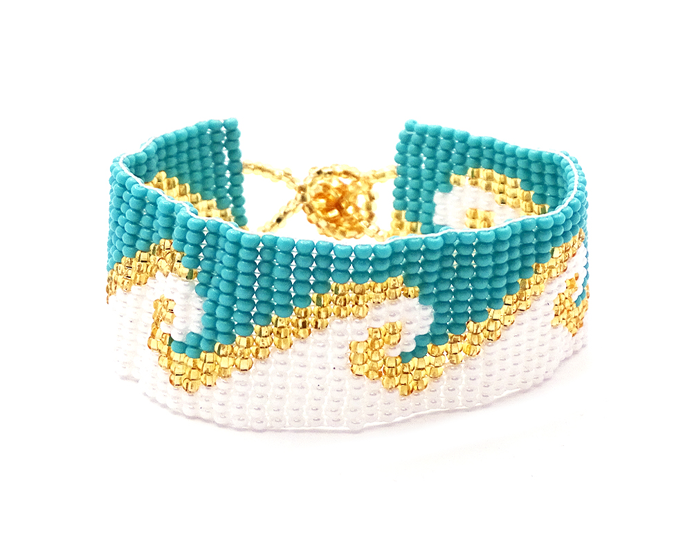 Handmade Czech glass seed bead wide strap bracelet with wave pattern design in turquoise blue, white, and gold color combination.