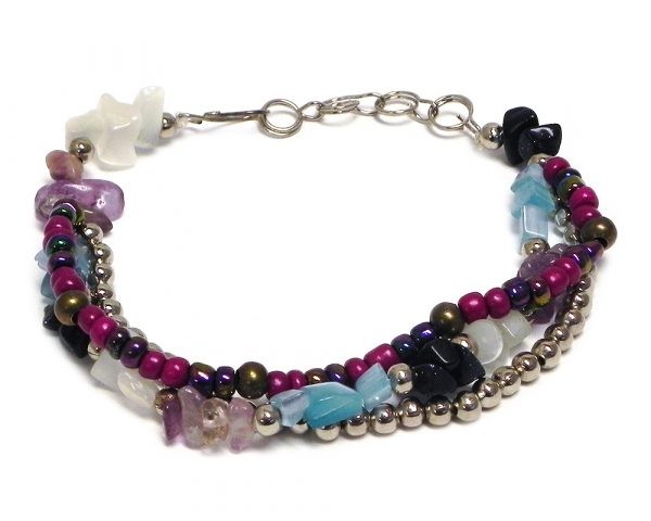 Handmade chip stone, large seed bead, and silver metal bead thick multi strand bracelet in purple, navy blue, light blue, and white color combination.