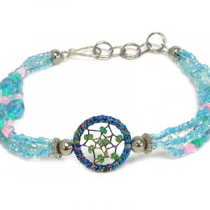 Handmade seed bead and crystal bead multi strand bracelet with round beaded sparkle thread dream catcher centerpiece in turquoise blue, aqua mint, green, and light pink color combination.