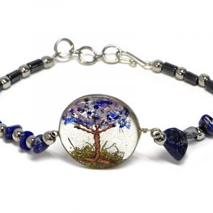 Handmade hematite, chip stone, and silver metal seed bead bracelet with round-shaped clear acrylic resin, copper wire, and crushed chip stone inlay tree of life centerpiece in blue sodalite and gray color combination.