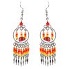 Native American inspired round metal hoop beaded chip stone earrings with seed bead and alpaca silver metal dangles in orange, red, and yellow color combination.