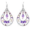Teardrop-shaped seed bead and alpaca silver metal webbed earrings with crystal bead dangle in purple, gold, and pink color combination.