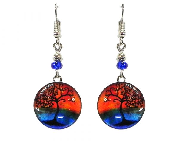 Round-shaped New Age themed sunset tree of life graphic acrylic dangle earrings with silver metal setting and beaded metal hooks in orange, blue and black color combination.