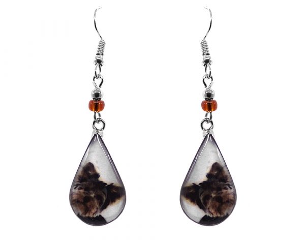 Teardrop-shaped Yorkie dog face graphic acrylic dangle earrings with silver metal setting and beaded metal hooks in white, brown, and black color combination.