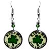 Round-shaped St. Patrick's Day holiday themed "Kiss Me I'm Irish" acrylic dangle earrings with beaded metal hooks in white and green color combination.