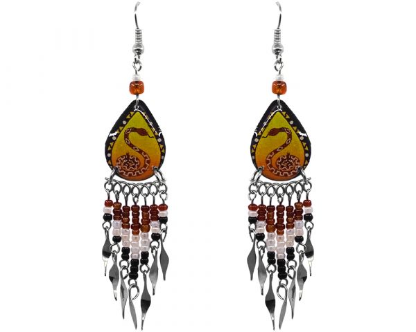 Handmade teardrop-shaped ceramic earrings with handpainted tribal pattern rattle snake animal graphic design and long seed bead and alpaca silver metal dangles in brown, white, black, brown, yellow, and orange color combination.