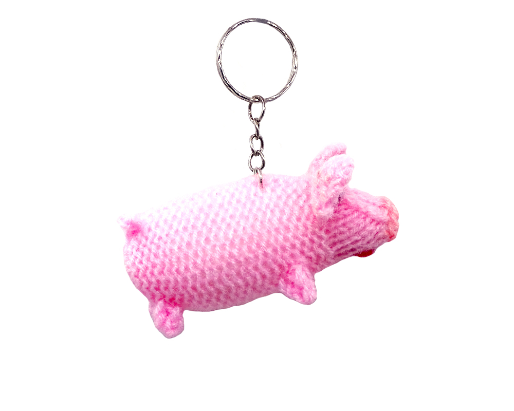 Handmade wool finger puppet keychain of a pig with silver metal key ring in pink color.