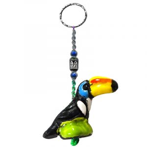 Handmade toucan animal keychain with handpainted ceramic, macramé string, a large bead, and metal keyring in black, white, turquoise blue, yellow, and green color combination.