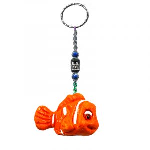 Handmade fish animal keychain with handpainted ceramic, macramé string, a large bead, and metal keyring in orange and white color combination.