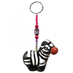 Handmade zebra animal keychain with handpainted ceramic, macramé string, a large bead, and metal keyring in black and white color combination.