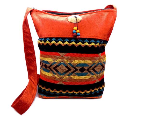 Handmade large cushioned square-shaped crossbody purse bag with Aztec inspired tribal print pattern material, vegan suede, and coconut button and beads in dark orange, tan, brown, black, golden yellow, and dark blue color combination.