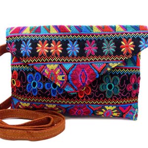 Handmade slim envelope purse bag with floral tribal huipil embroidered cotton material, magnetic snap closure, and a crossbody strap in black, orange, and multicolored color combination.