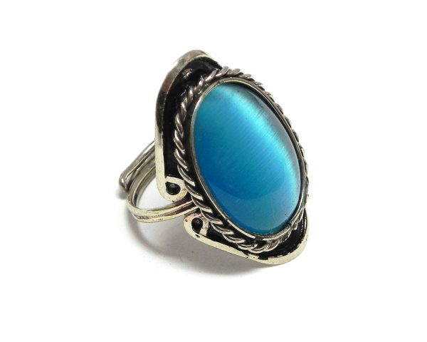 Handmade oval-shaped cat's eye glass bead cabochon on adjustable alpaca silver metal ring with rope edge border in turquoise blue color.