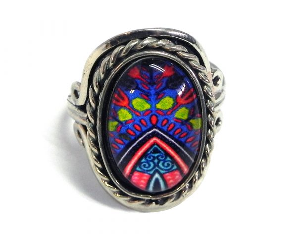 Handmade small oval-shaped acrylic New Age themed pattern graphic design on alpaca silver metal ring with rope edge border in blue, red, blue, lime green, turquoise, and navy color combination.