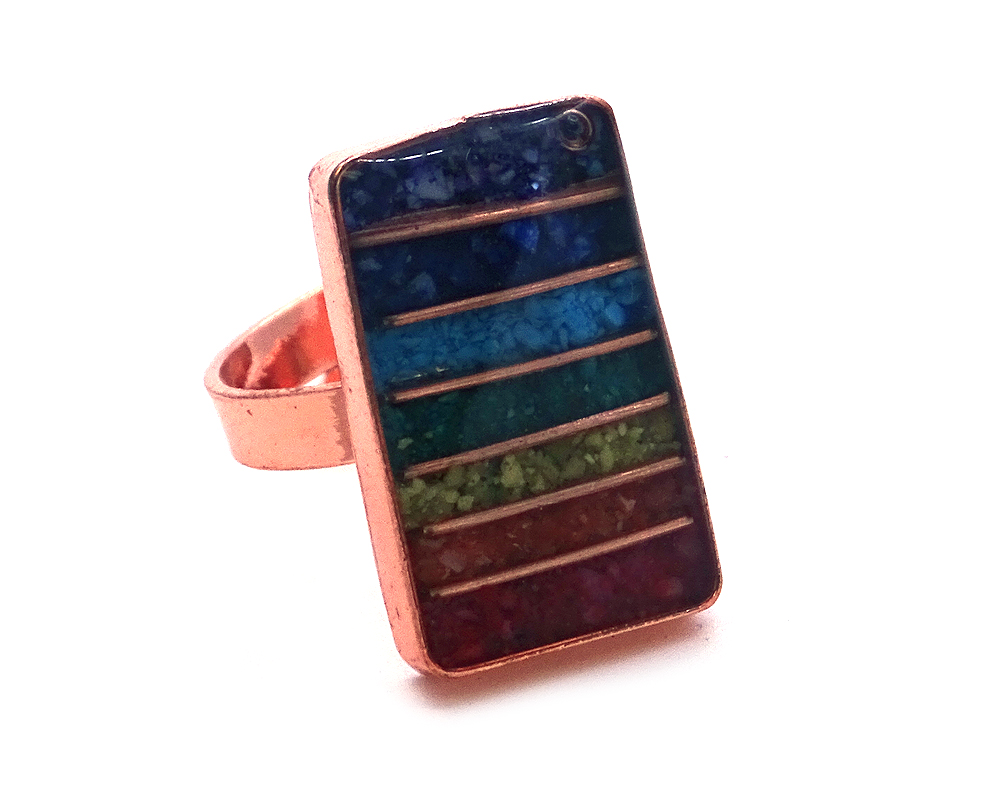 Rectangle-shaped acrylic resin, copper wire, and crushed chip stone inlay orgonite cabochon with 7 chakra rainbow striped pattern on adjustable copper metal ring.