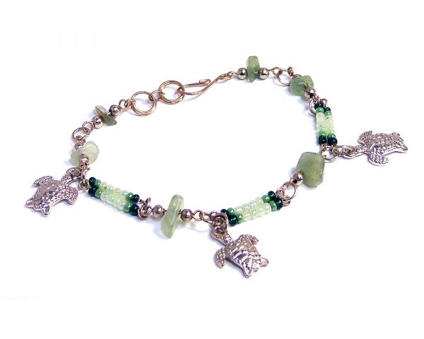 Handmade seed bead and chip stone alpaca silver metal chain bracelet with three sea turtle charm dangles in green and light green color combination.