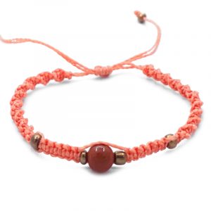 Macramé pull tie bracelet with brown goldstone gemstone ball bead and seed bead centerpiece in peach color.