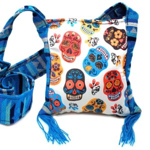 Handmade small square-shaped padded crossbody purse bag with woven tribal print striped pattern, multicolored floral Day of the Dead sugar skull design, and fringe in white, red, turquoise blue, golden yellow, and black color combination.