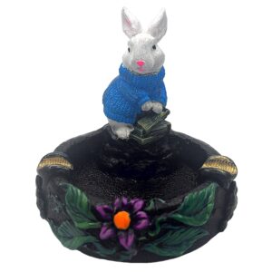 Handcrafted round incense holder ash tray with a flower and leaf design and 3D figurine of a rabbit holding money in turquoise, green, black, and gold color combination.